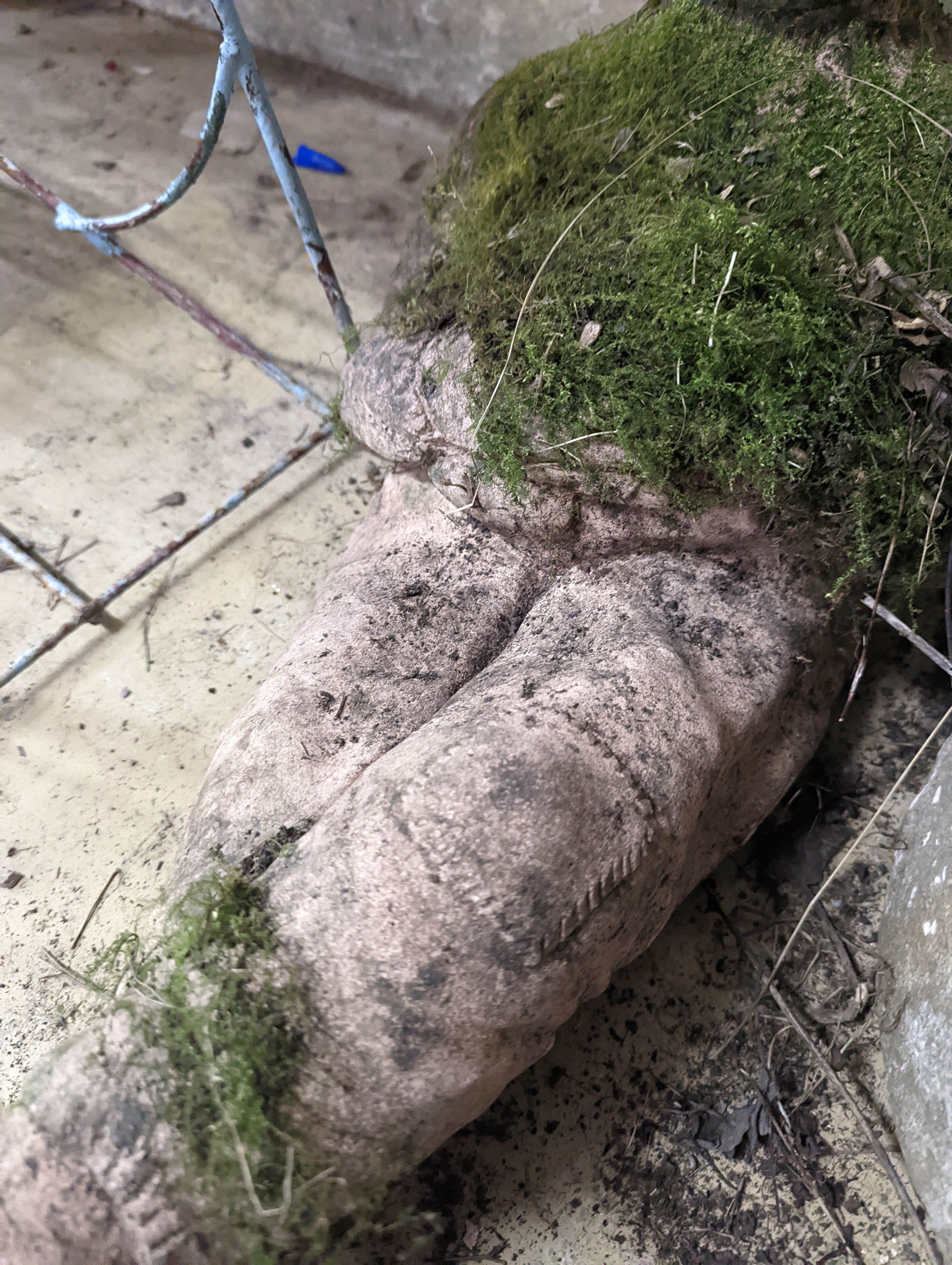 Two small circular mill stones, a reconstituted stone gargoyle and a terracotta reclining pixie garden ornament